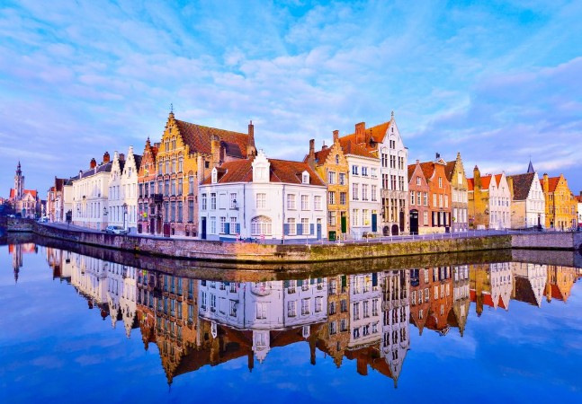 Afbeeldingen van Cityscape view of Bruges and traditional houses reflected in water at sunrise in Belgium