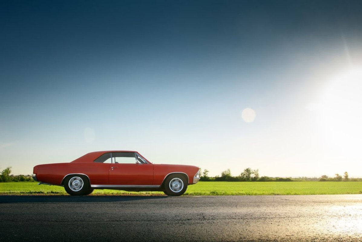 Image de Retro red car standing on asphalt road at sunset