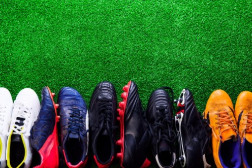 Afbeeldingen van Various cleats against green artificial turf studio shot