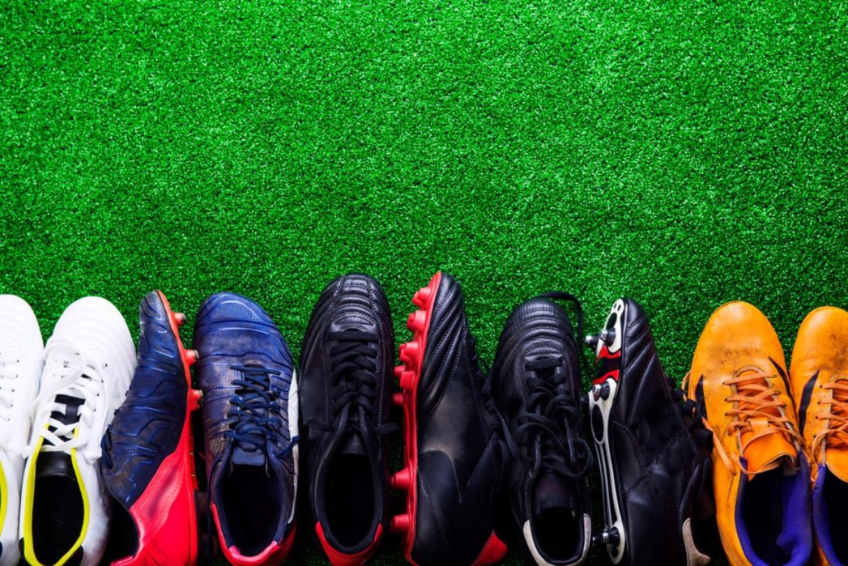 Afbeeldingen van Various cleats against green artificial turf studio shot