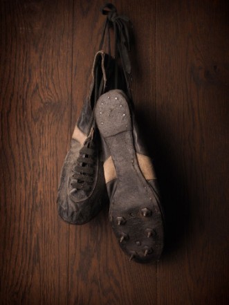 Obrázek Old used sports shoes on a rustic wooden wall