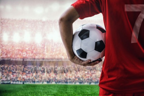 Kép Soccer football player in red team concept holding soccer ball in the stadium