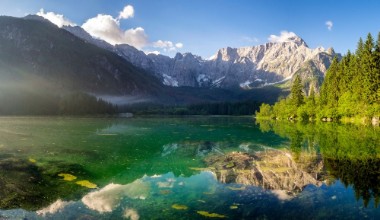 Afbeeldingen van Alpine lake at dawn beautifully lit mountains