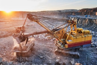 Picture of Mining excavator loading granite or ore into dump truck