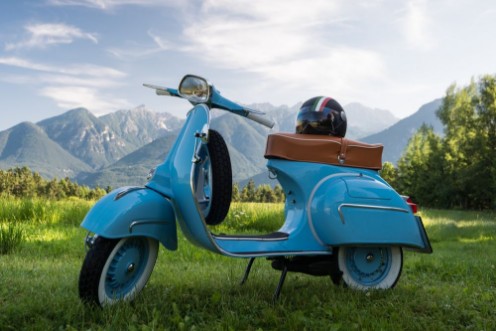 Afbeeldingen van Blaue Vespa vor Bergkulisse auf Feld