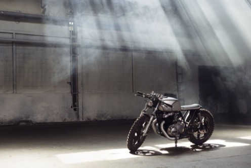 Poza cu Motorcycle standing in dark building in rays of sunlight