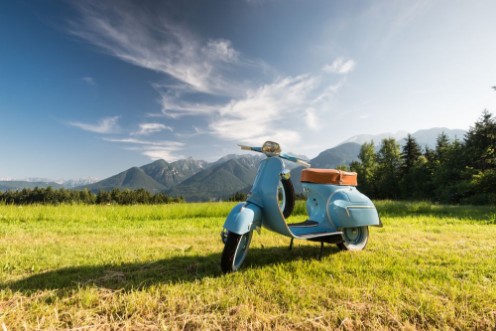 Picture of Blaue Vespa vor Bergkulisse auf Feld