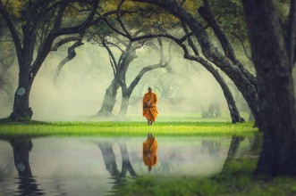 Afbeeldingen van Monk hike in deep forest reflection with lake Buddha Religion c
