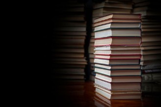 Picture of Stack of books against the background of a number of books a place for an inscription