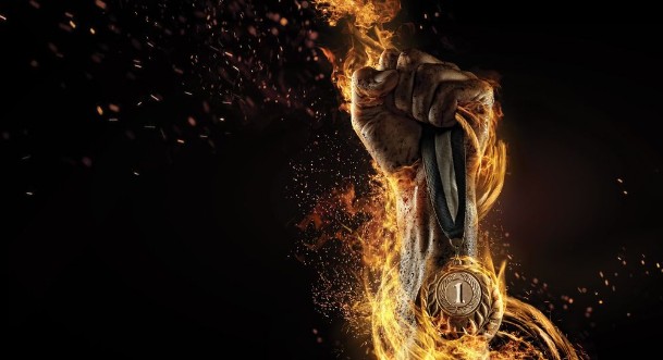 Picture of Sport Mans hand holding up trophy medal Winner in a competition Fire and energy