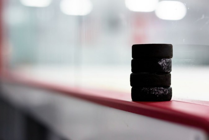 Hockey pucks along the boards photowallpaper Scandiwall
