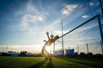 Picture of Football player is training at the field on a sunset background