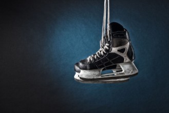 Afbeeldingen van Mens hockey skates hanging on a dark background