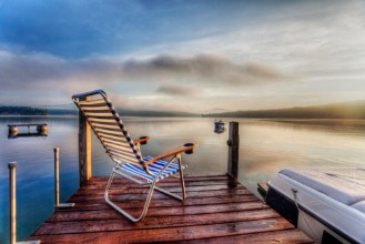 Bild på Chair sitting at the end of a dock in very early morning summer light