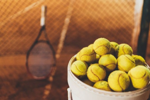 Picture of Tennis balls at hopper tennis racket in the blurred background sportive and healthy lifestyle