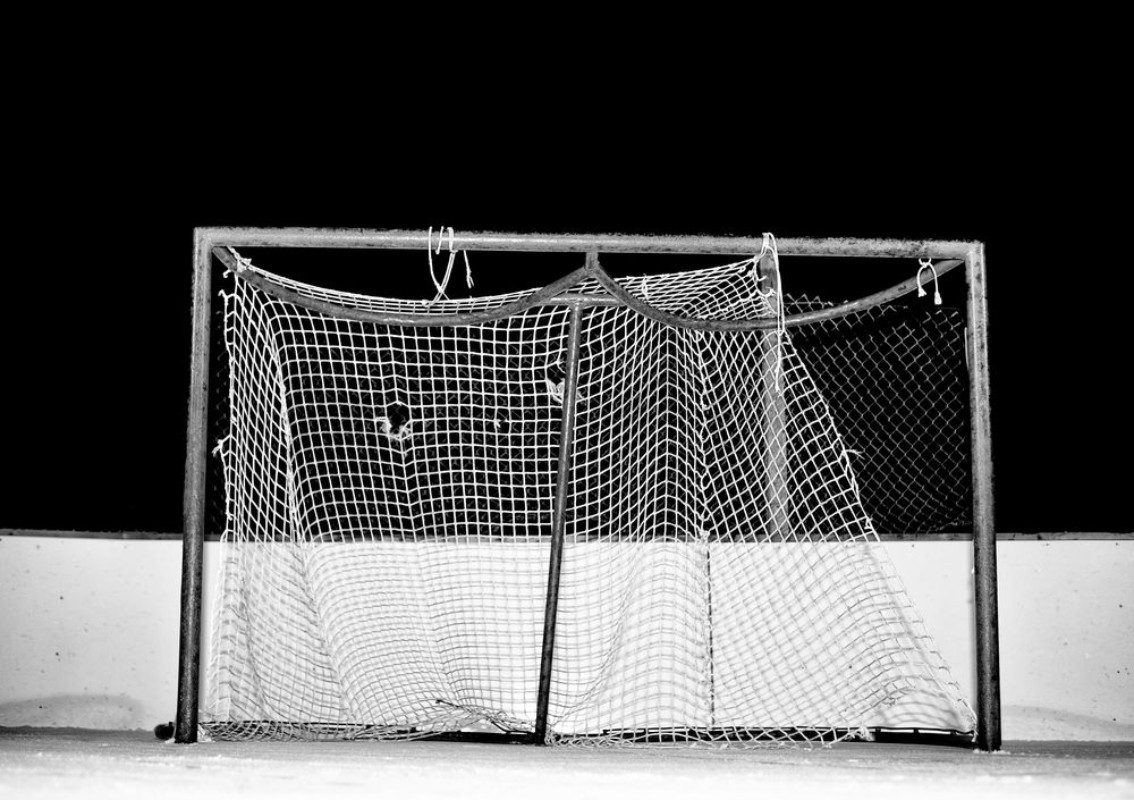 Image de Close-up of tattered and frayed mesh on a hockey net on an outdoor ice skating rink at night in black and white