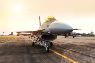 Afbeeldingen van Falcon fighter jet military aircraft parked in the base airforce on sunset 