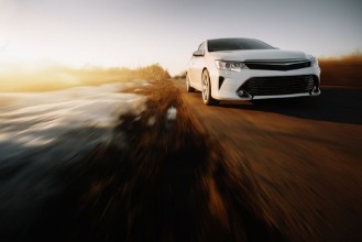 Picture of White modern car drive at asphalt road at sunset