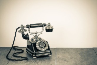 Bild på Vintage background with old rotary telephone on wood table