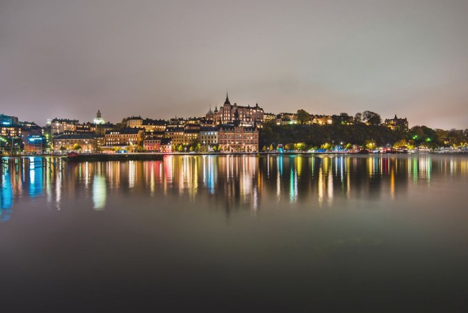 Picture of Stockholm city lights and night view of Sodermalm district buildings reflected in the water Evening Stockholm cityscape with illumination Riddarfjarden marina and Soder Malarstrand embankment