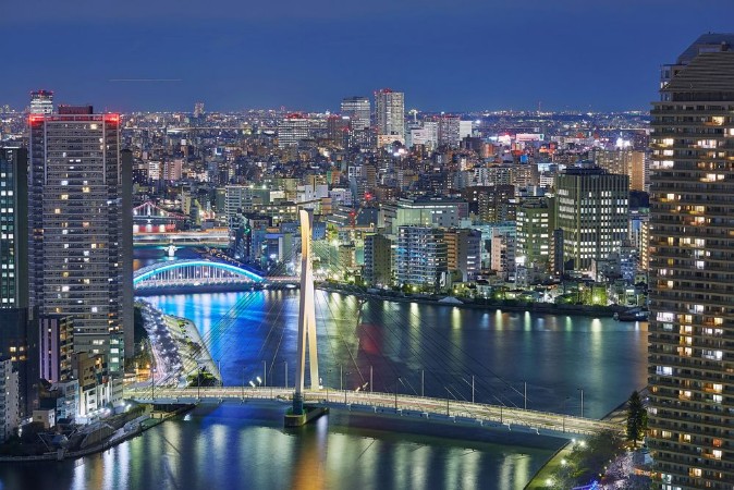 Night Tokyo panorama with wide angle aerial view of Sumida river in illuminated Tokyo with bright bridges skyscrapers and dark cloudy sky photowallpaper Scandiwall