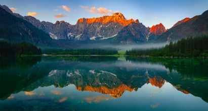 Image de Panoramic view of beautiful white winter wonderland scenery in the Alps with mountain summits reflecting in crystal clear mountain lake on a colorful dawn