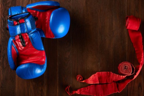 Afbeeldingen van Sport background with blue and red gloves and red bandage on wooden background