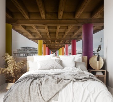 Bild von Shot under pier with color painted columns on the beach at sunset