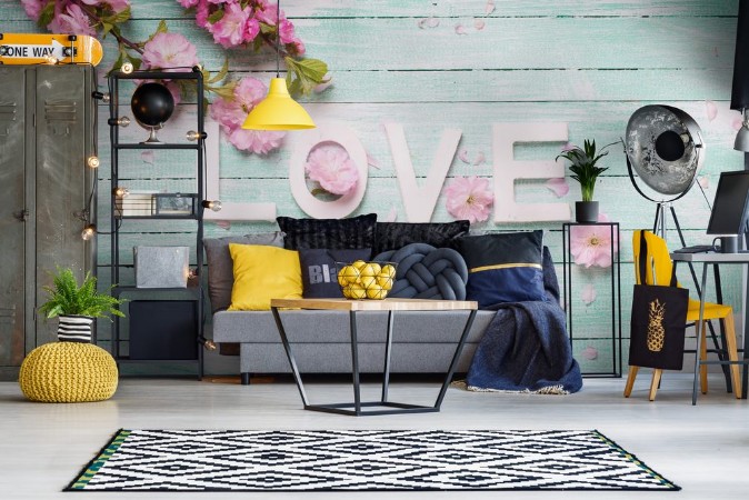 Bild på Word love and  border from pink almond flowers on turquoise wooden background