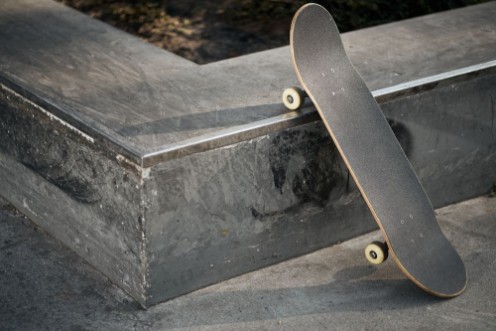 Afbeeldingen van Zwart skateboard in betonnen skatepark