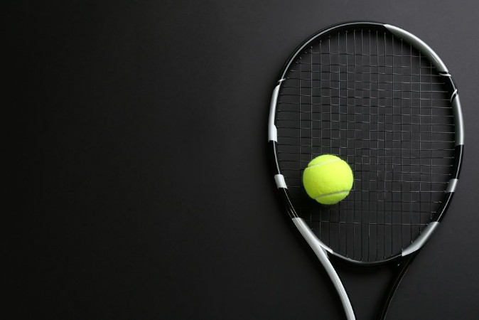 Afbeeldingen van Tennis racket and ball on black background