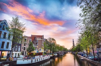 Afbeeldingen van The most famous canals and embankments of Amsterdam city during sunset General view of the cityscape and traditional Netherlands architecture