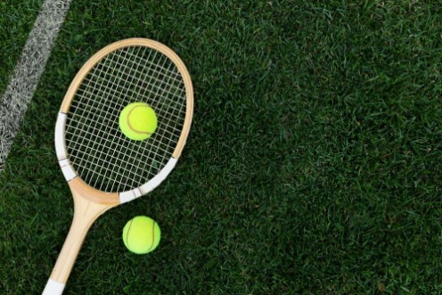 Picture of Retro tennis racket on natural grass with balls top view with copy space