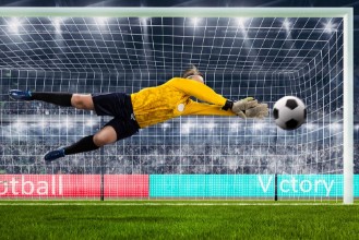 Afbeeldingen van Female goalie is jumping for the ball on crowded stadium