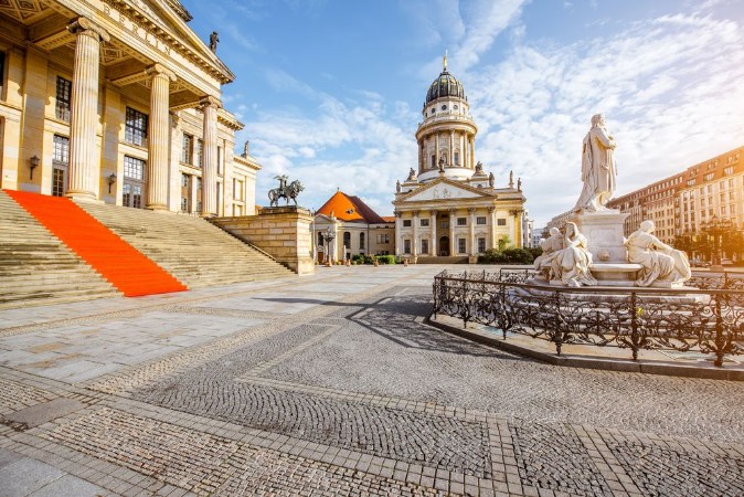 Bild på Viiew on the Gendarmenmarkt square with concert house building and French cathedral during the morning light in Berlin city