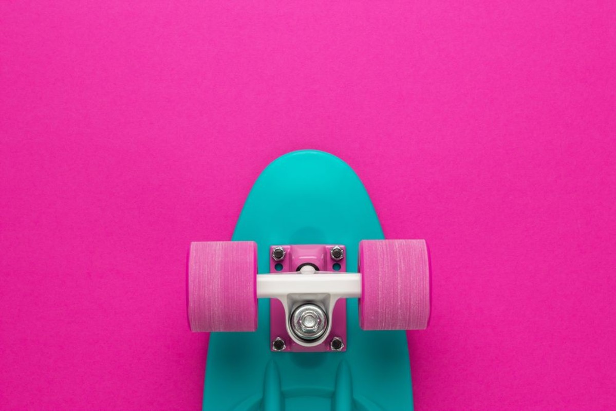 Afbeeldingen van Plastic mini cruiser board on deep pink with background with copy space