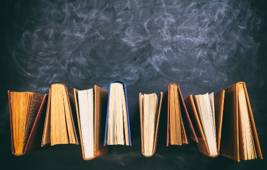 Image de Vintage books standing on blackboard background - top view