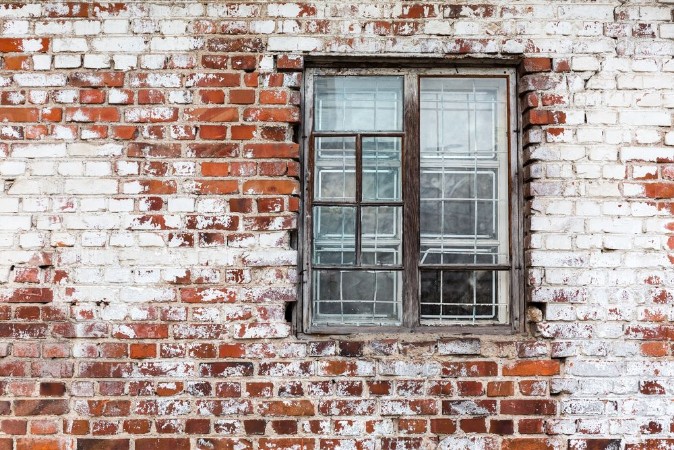 Wooden window on weathered red brick wall painted white photowallpaper Scandiwall