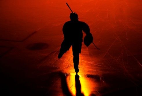 Picture of One  man ice hockey player in arena silhouette isolated on black background