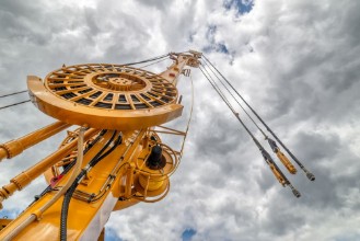 Bild på The boom of a drilling machine and a crane against the sky