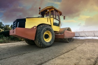 Afbeeldingen van Steamroller paving a dirt road before paving