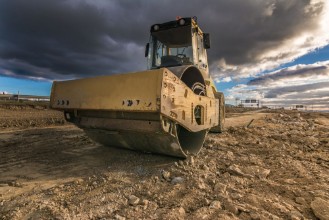 Steamroller performing leveling work on a road under construction paveikslėlis