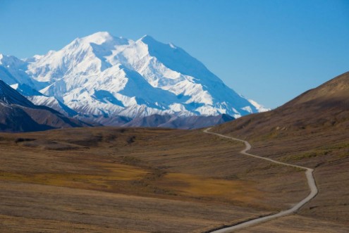 Afbeeldingen van Mount McKinleys snowy peak with the park road in the foreground