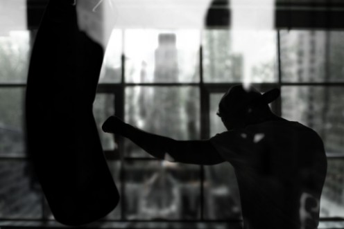 Boxer hits a punching bag against the window training photowallpaper Scandiwall