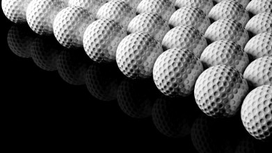 Bild von Golf balls isolated on black background with reflection
