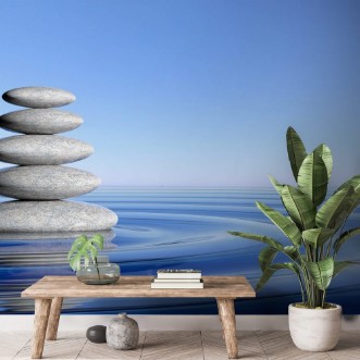 Picture of Zen stones stack from large to small  in water with circular waves and blue sky